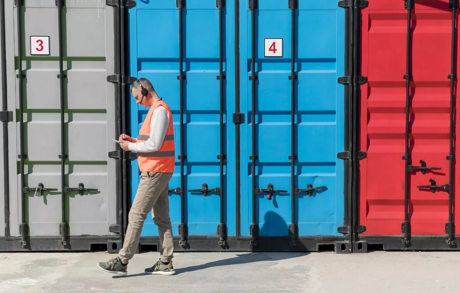 A man walking by containers